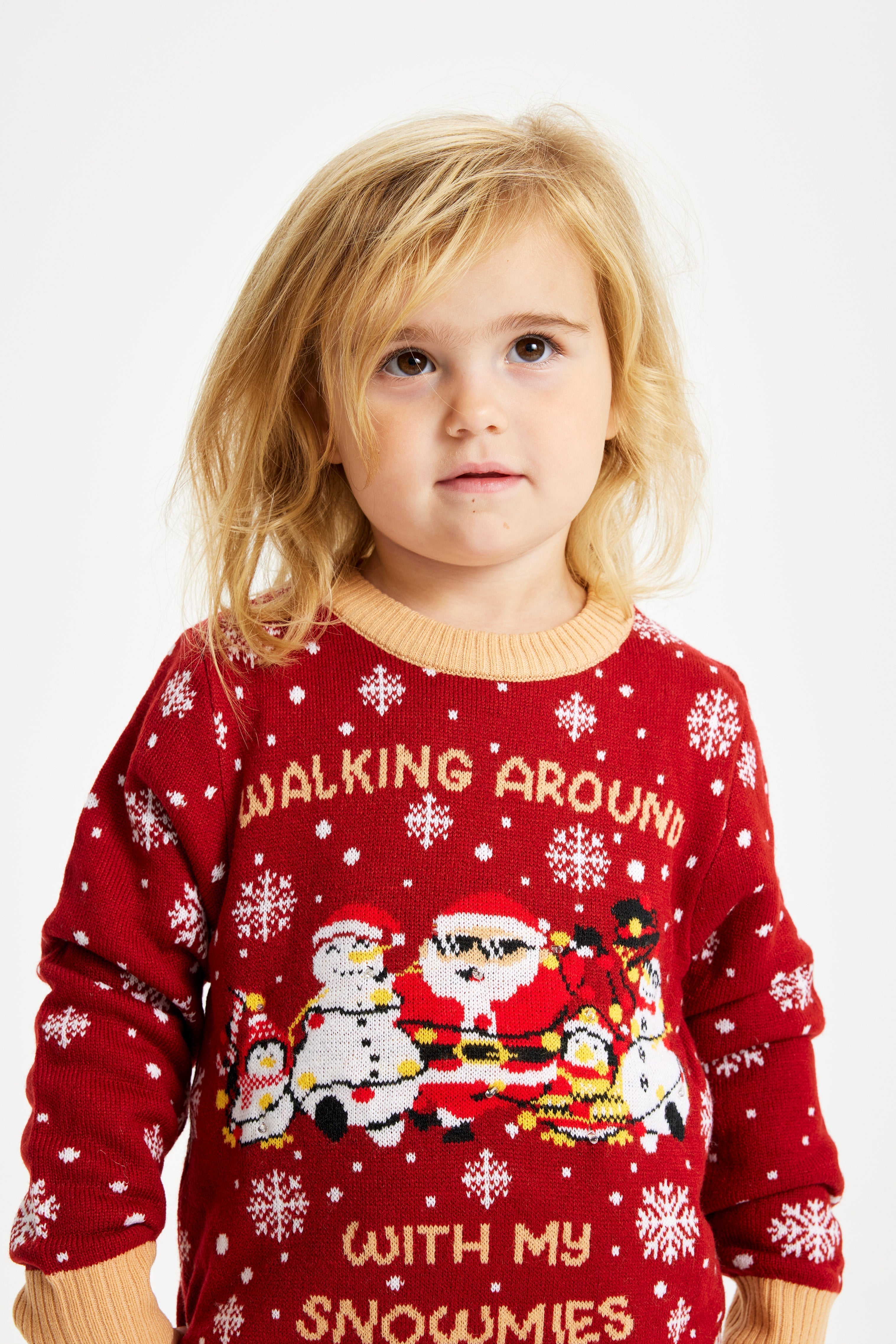 Un bambino che indossa un maglione natalizio rosso con la scritta